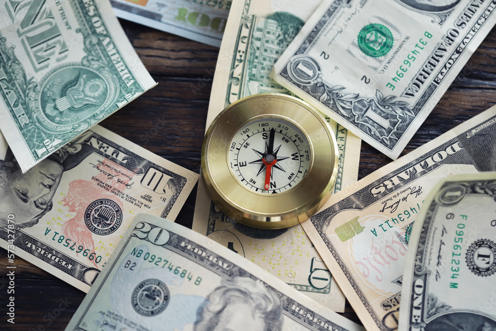 Money bill with golden Compass. Bullets and cartridge cases as a military concept. Close up US Currency and compass. business, financial idea, concept, symbol of crisis, inflation Money bill with golden Compass. Bullets and cartridge cases as a military concept. Close up US Currency and compass. business, financial idea, concept, symbol of crisis, inflation