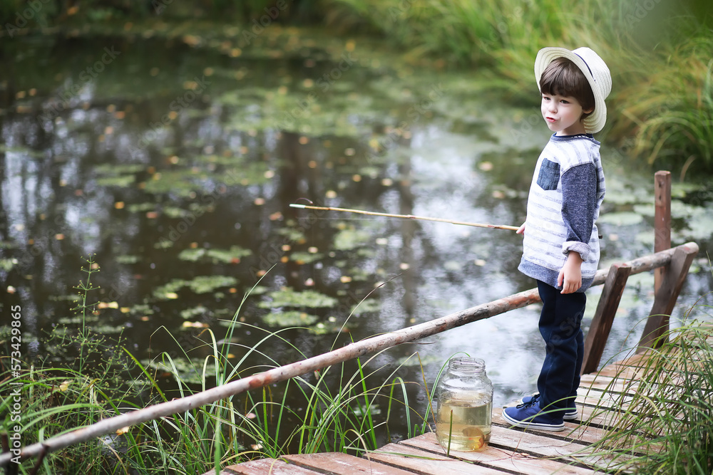 A child is fishing in the autumn morning. Autumn sunset on the pond. A fisherman with a fishing rod on the walkway.