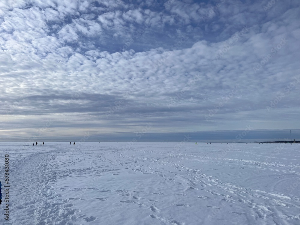 snow valley of frozen finland gulf. Beautuful spindrift clouds on blue sky
