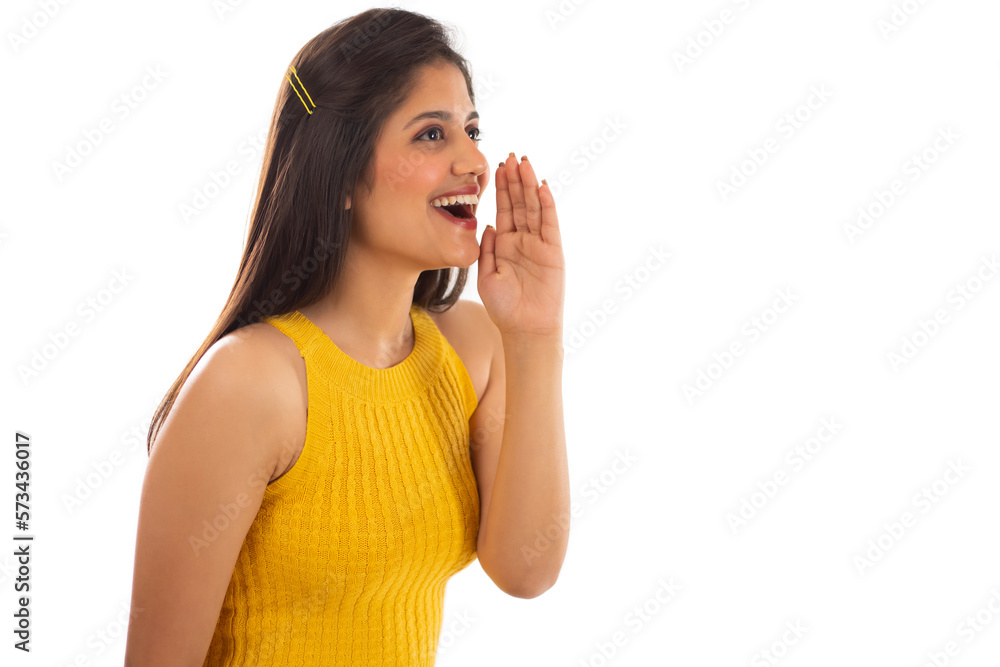 Beautiful woman calling someone with hand beside mouth against white background Beautiful woman calling someone with hand beside mouth against white background