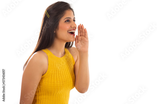 Beautiful woman calling someone with hand beside mouth against white background