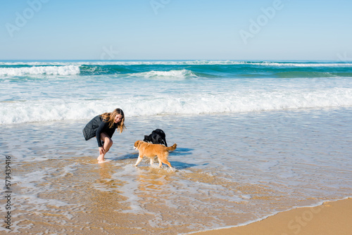 Young girl walking and playing on the Oceanic beaches of Aquitaine with their Puppys photo