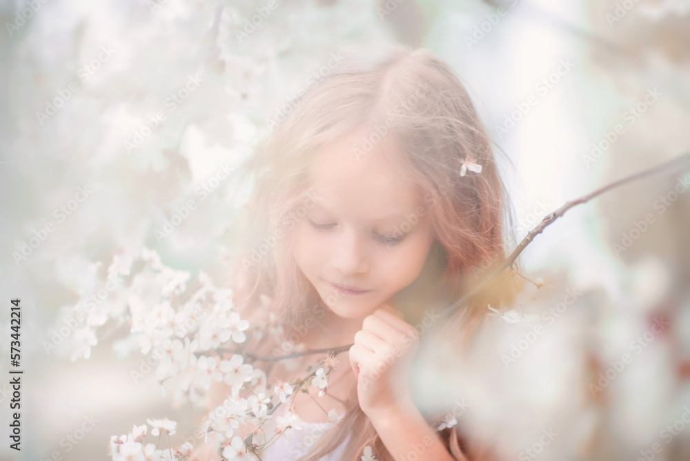 Spring. A beautiful little girl with long hair and flowers in her hair near a flowering tree. Apple tree in bloom. The Cherry Orchard. Apple orchard. Blooming apple tree. Portrait. tender baby Spring. A beautiful little girl with long hair and flowers in her hair near a flowering tree. Apple tree in bloom. The Cherry Orchard. Apple orchard. Blooming apple tree. Portrait. tender baby