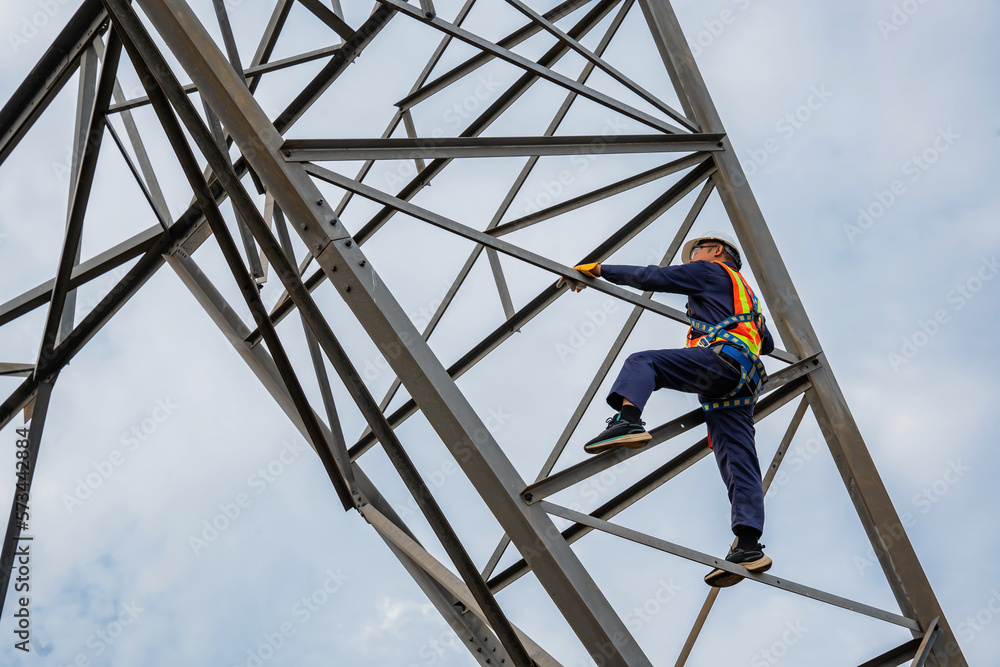 Asian electrical engineer wearing safety gear working high voltage pylon Engineering work on high-voltage pylons at power stations using drones to view power generation planning from high-voltage pylo