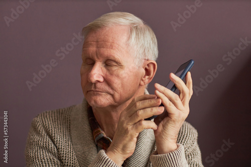 Blind man listening to audio assistant on smartphone photo