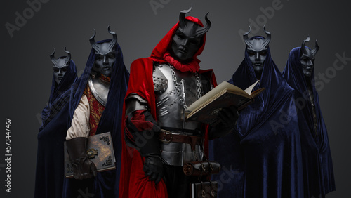 Fotografi Portrait of dark cult members dressed in robes and their leader holding book