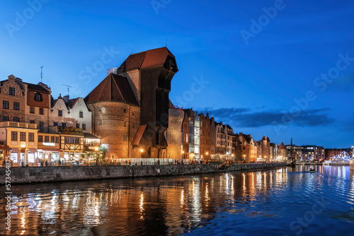 Old buildings and Gdansk Crane Gate in front of Motlawa river at night photo