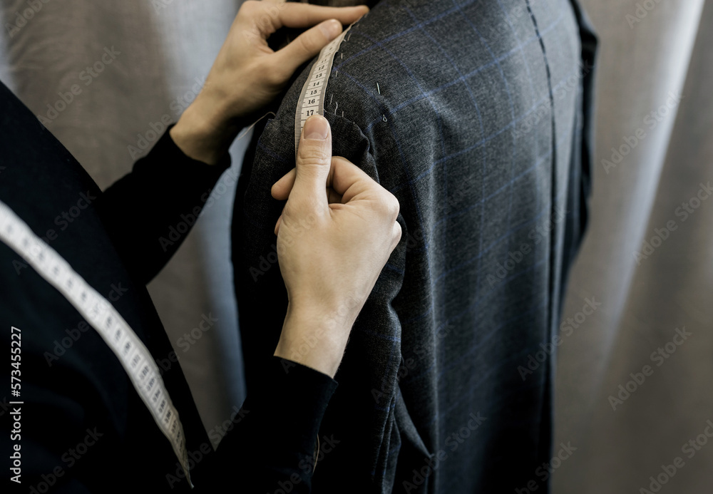 Tailor measures a man.
