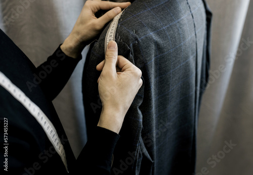Tailor measures a man.