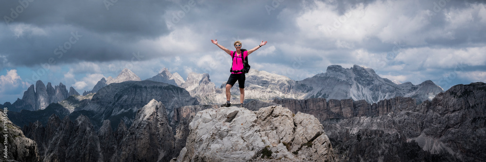 Senior woman standing with arms raised at Langkofel, Dolomites, Italy Senior woman standing with arms raised at Langkofel, Dolomites, Italy