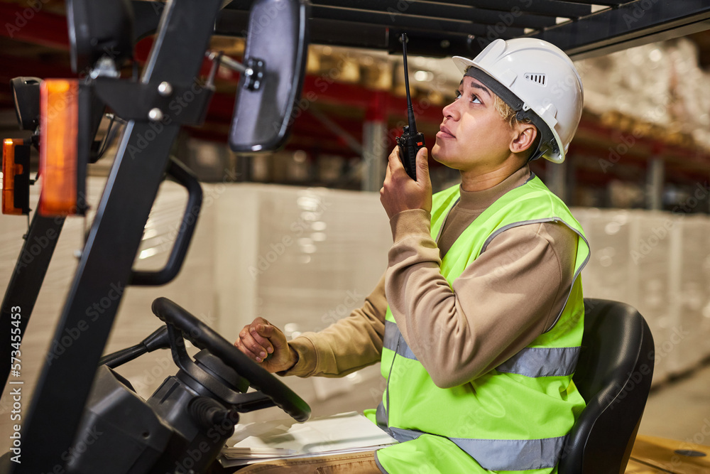 Side view portrait of female worker wearing hardhat while operating