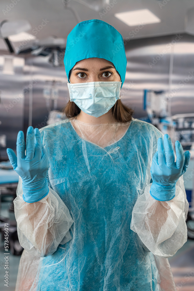 female doctor in blue coat holding stethoscope and pills in hand while standing in operating female doctor in blue coat holding stethoscope and pills in hand while standing in operating