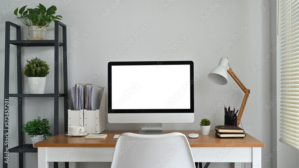 Modern workplace, home office interior with blank computer screen on wooden desk. Empty screen for your advertising design Modern workplace, home office interior with blank computer screen on wooden desk. Empty screen for your advertising design