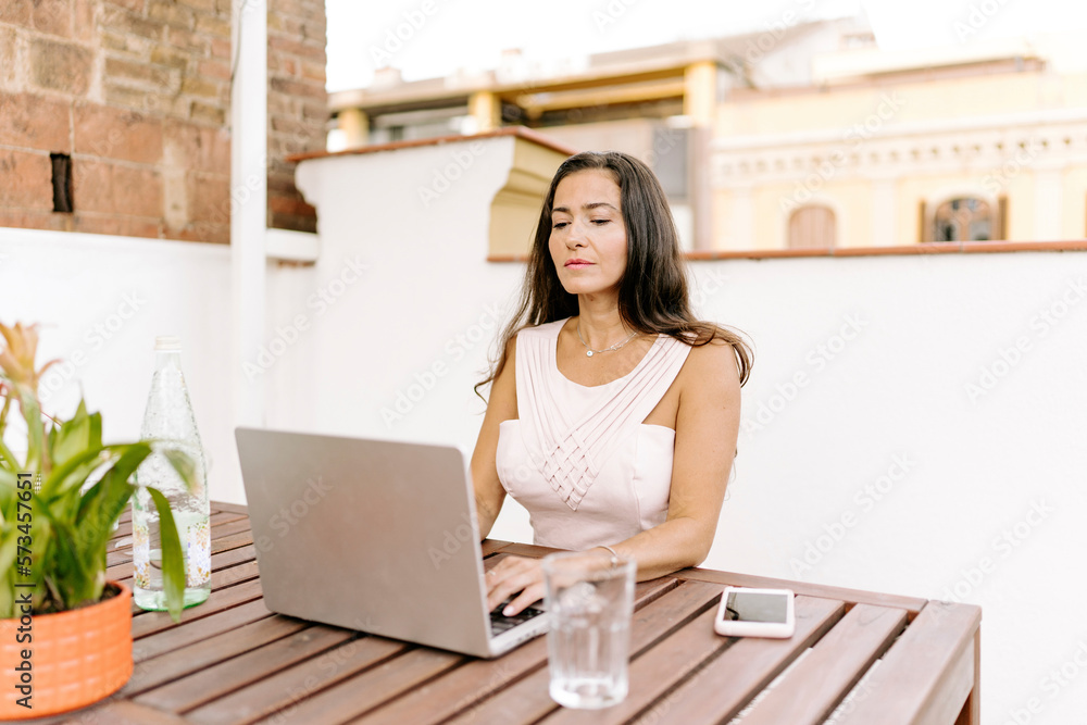 Freelancer working on laptop at table Freelancer working on laptop at table