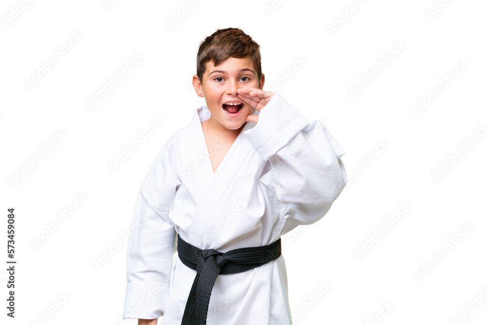Little caucasian kid doing karate over isolated chroma key background shouting with mouth wide open Little caucasian kid doing karate over isolated chroma key background shouting with mouth wide open