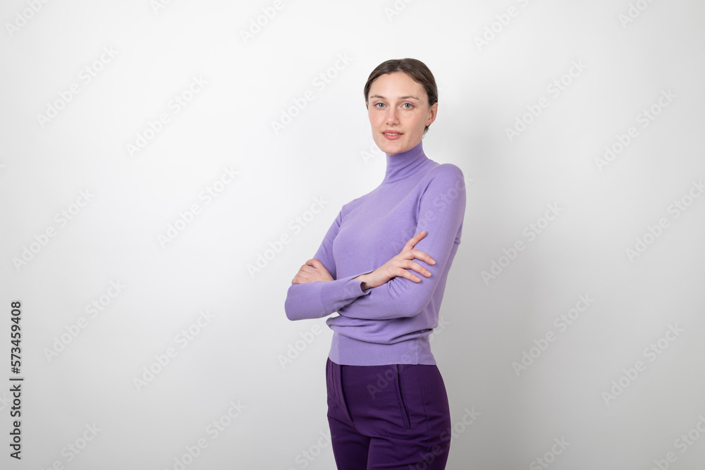 Smiling young woman standing with arms crossed over white background Smiling young woman standing with arms crossed over white background