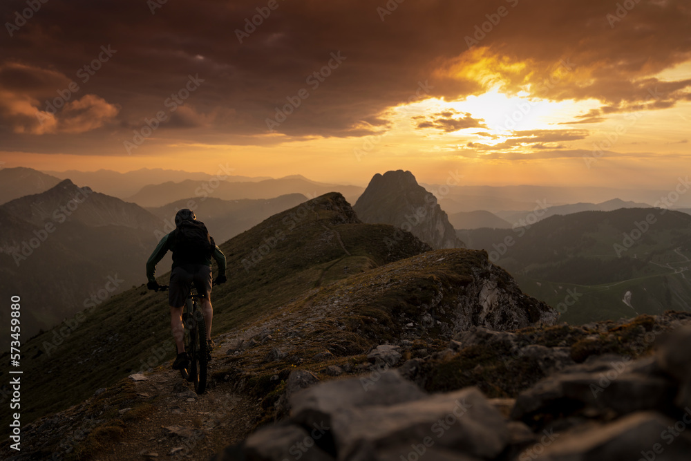 Man cycling on mountain at sunset Man cycling on mountain at sunset