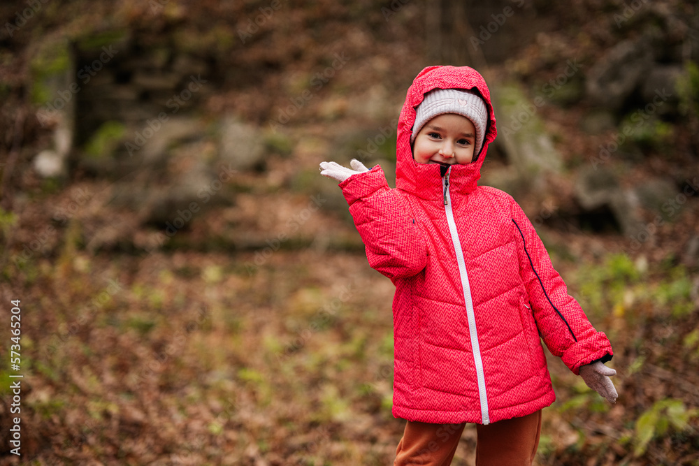 Portrait of baby girl in pink hooded jacket at autumn forest. Portrait of baby girl in pink hooded jacket at autumn forest.