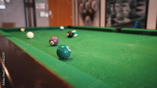 Billiard table trick shot jumping over and sinking the ball in the pocket photo