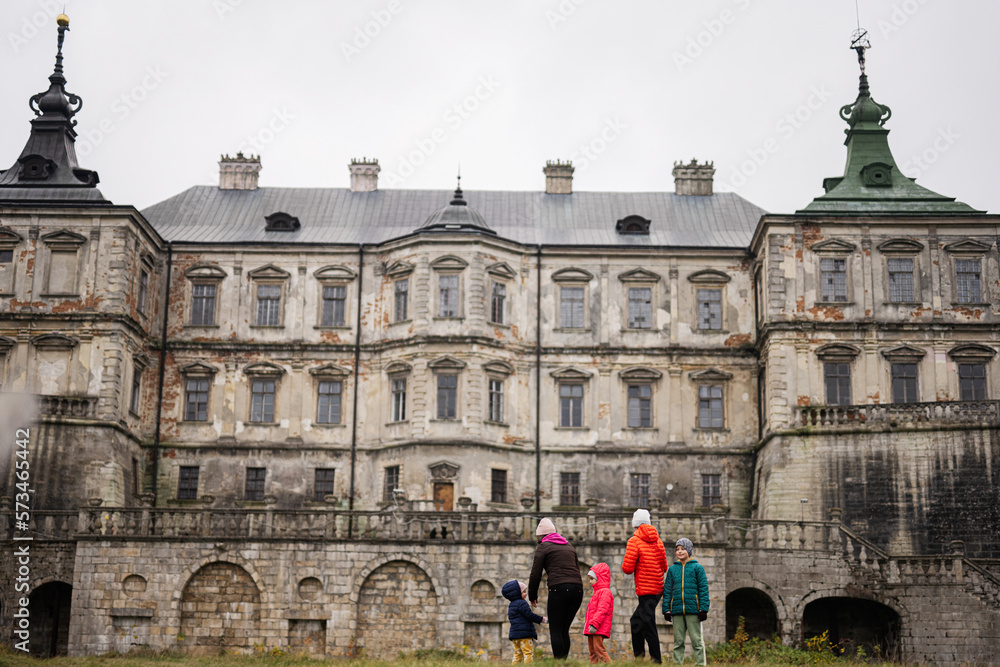 Back of mother with four kids visit Pidhirtsi Castle, Lviv region, Ukraine. Family tourist.