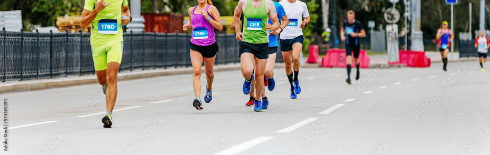 group male and female athletes run city marathon race