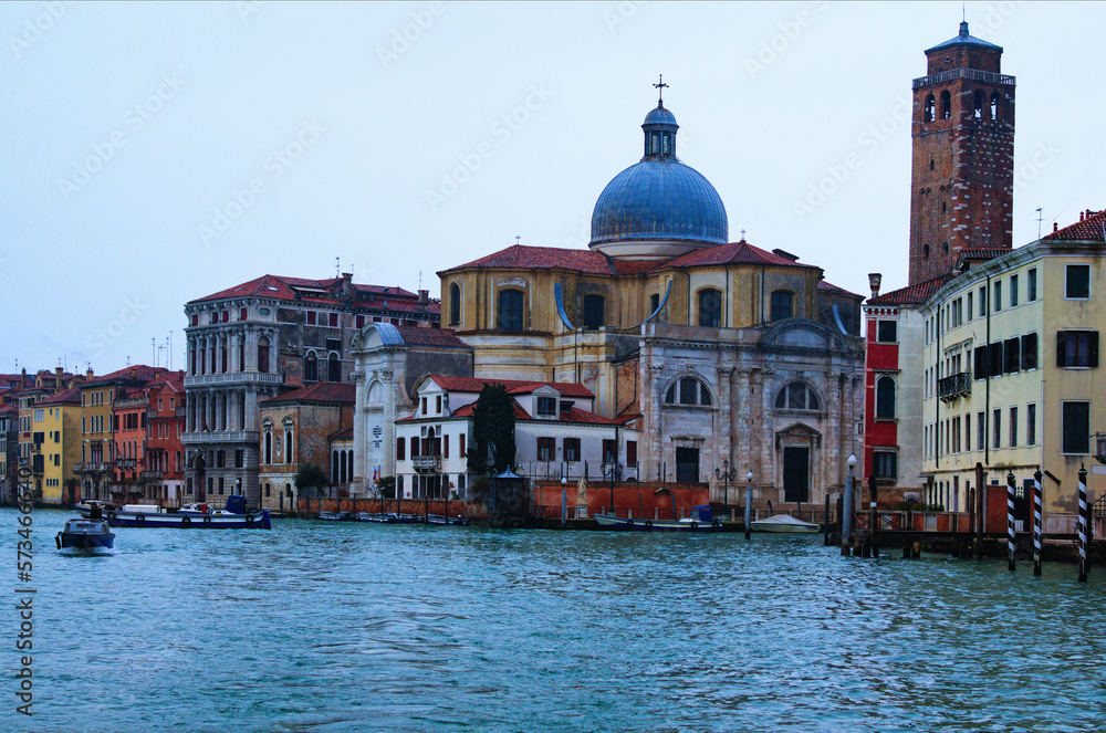 Picturesque panoramic view over Grand Canal in Venice. Moored boats near colorful ancient buildings.  Winter drizzle morning in Venice. Famous touristic place and travel destination in Europe