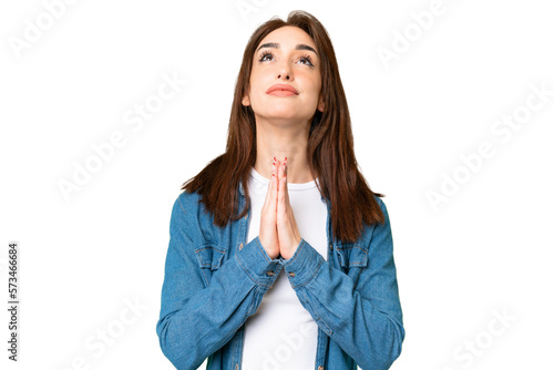 Fotografie Young caucasian woman over isolated chroma key background keeps palm together