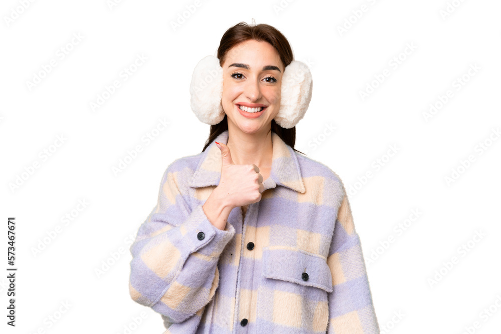 Young caucasian woman wearing winter muffs over isolated chroma key background giving a thumbs up gesture Young caucasian woman wearing winter muffs over isolated chroma key background giving a thumbs up gesture