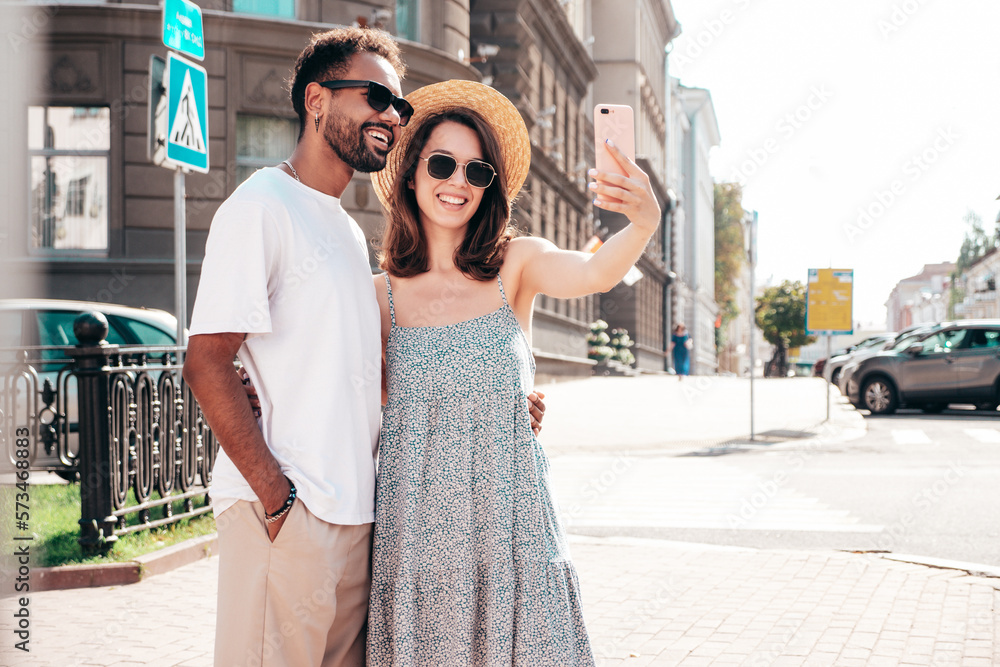 Smiling beautiful woman and her handsome boyfriend. Woman in casual summer clothes. Happy cheerful family. Female having fun. Sexy couple posing in the street at sunny day. Taking selfie photos