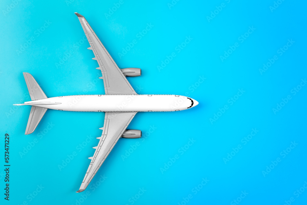 White plane, airplane on a blue background, flat lay, copy space.