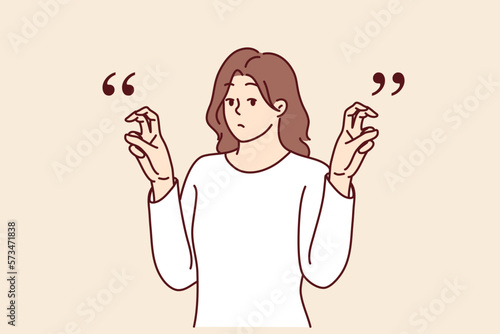 Young woman gesticulates with quotation marks with fingers while saying sarcastic words or hints. Teenager girl raises hands demonstrating quotes before telling sarcastic story or difficult joke 