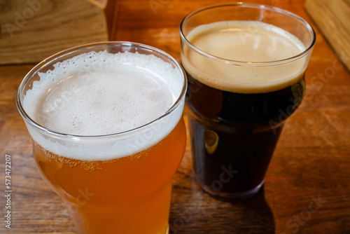 Light and dark beer in glass glasses on a wooden table in a bar or pub