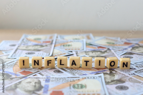 Inflation text on a lettering block placed on a dollar bill. 
