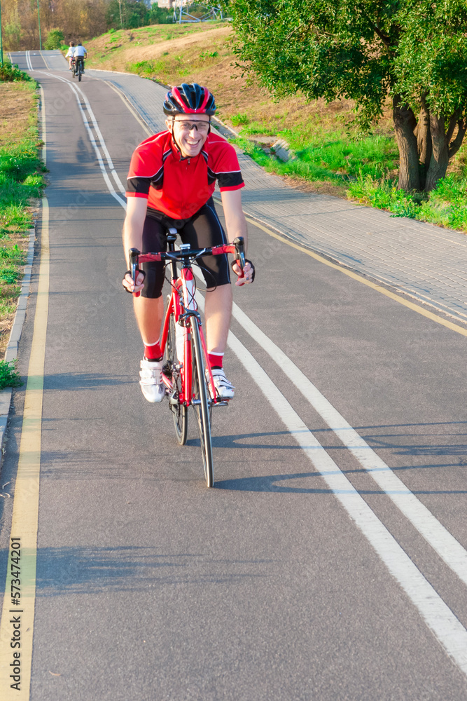 Obraz premium Road Cycling. One Emotional Male Cyclist Riding Road Bike Uphill Equipped with Summer Bike Outfit Posing Outdoor During Training.
