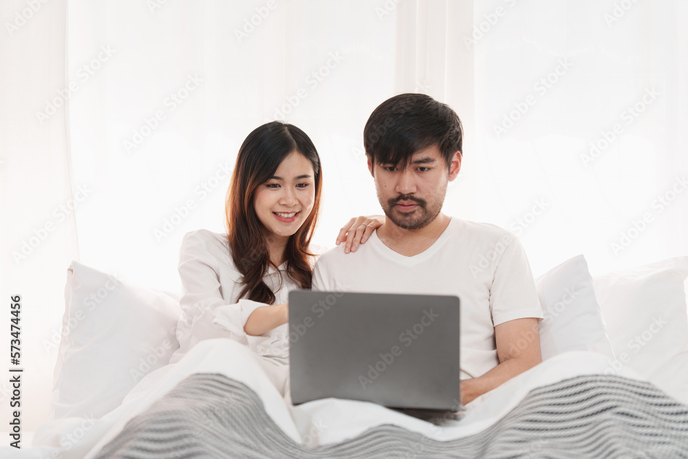 Beautiful asian couple in love and smiling sitting on bed. Romantic moment, relationships, family concept. Beautiful asian couple in love and smiling sitting on bed. Romantic moment, relationships, family concept.