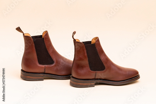 Footwear ideas. Closeup of Pair of Classic Leather Chealsea Boots As Still Life Concepts Placed Close to One Another Over Beige