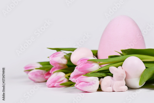 Easter arrangement with tulip flowers, pink easter bunny and painted eggs