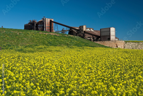abandoned sulfuric acid plant with green and yellow field