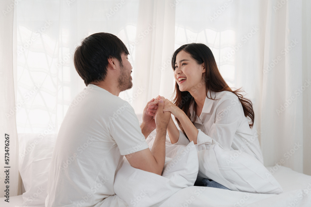 Beautiful asian couple in love and smiling sitting on bed. Romantic moment, relationships, family concept. Beautiful asian couple in love and smiling sitting on bed. Romantic moment, relationships, family concept.