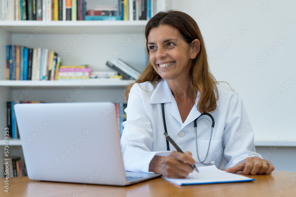 Beautiful mature adult female doctor at work at office Beautiful mature adult female doctor at work at office