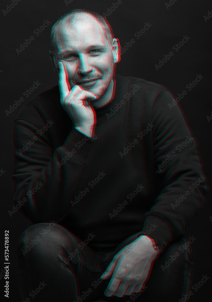 Lifestyle concept. Studio portrait of happy man with sweatshirt looking at camera with smile and holding one hand on cheek. Red and blue color split effect style. 3D glitch virtual reality effect Lifestyle concept. Studio portrait of happy man with sweatshirt looking at camera with smile and holding one hand on cheek. Red and blue color split effect style. 3D glitch virtual reality effect
