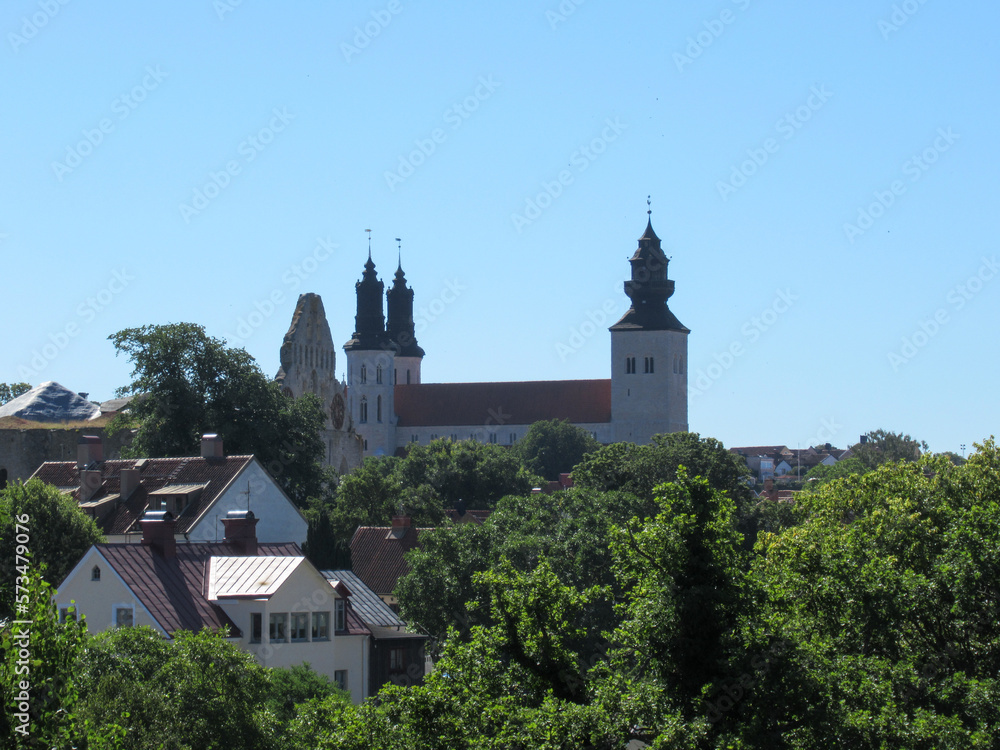 Visby Cathedral and houses behind green trees