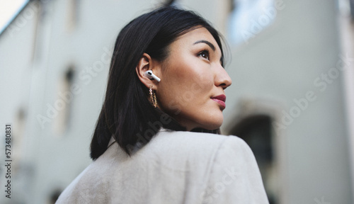 Business woman listening to music with earphones in the city