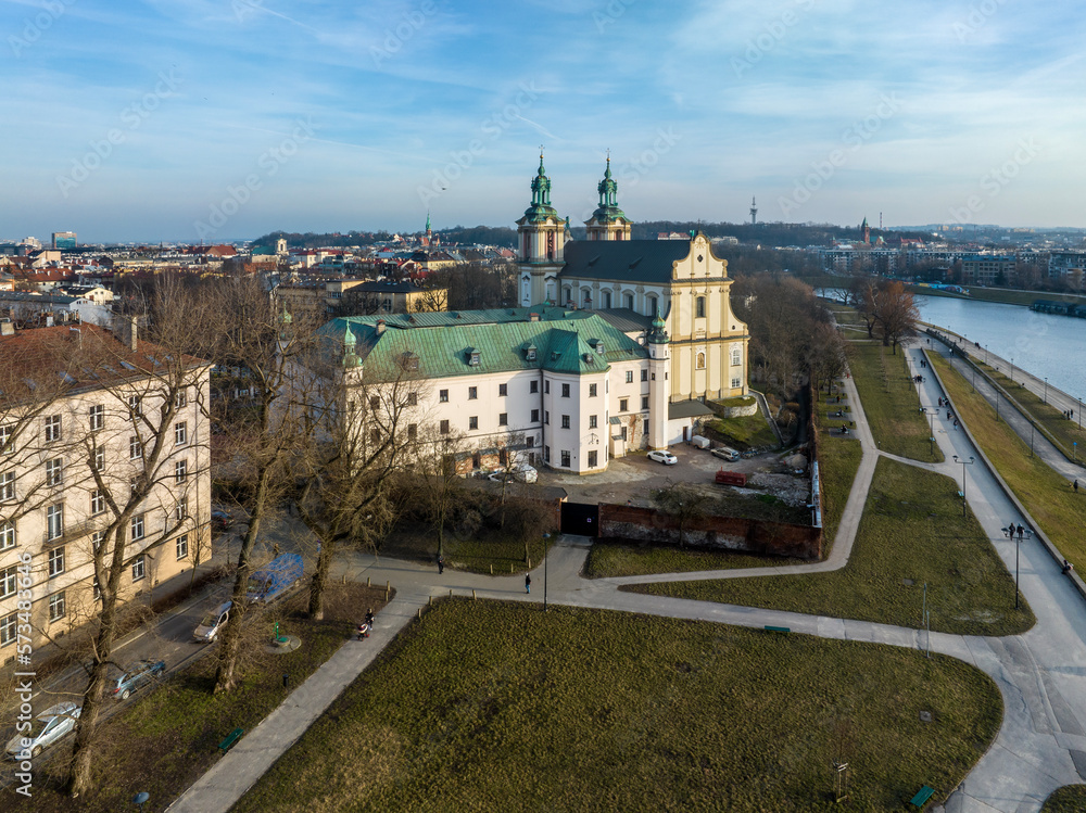 Skalka. St. Stanislaus church and Paulinite monastery in Krakow, Poland. Historic burial place of distinguished Poles. Aerial view. Winter, sunset light. Promenade with walking people