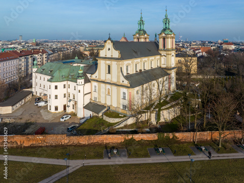 Skalka. St. Stanislaus church and Paulinite monastery in Krakow, Poland. Historic burial place of distinguished Poles. Aerial view. Winter, sunset light. Promenade with walking people