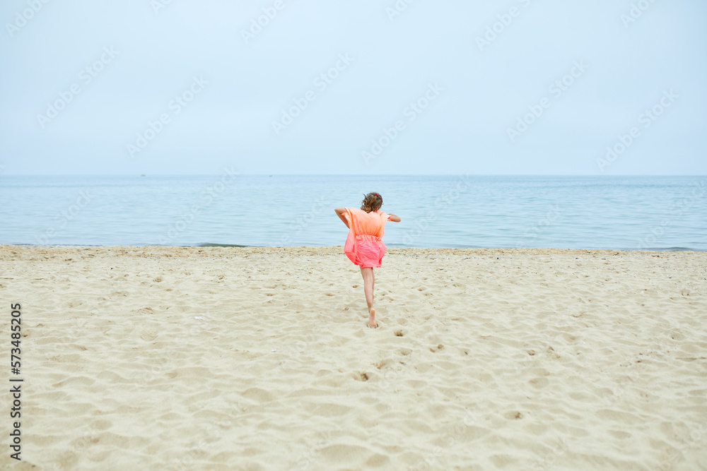Happy, joyful little girl run on the beach Happy, joyful little girl run on the beach
