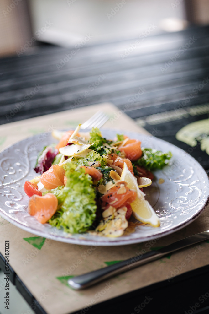 Fresh salad with salted red fish and nuts on wooden table Fresh salad with salted red fish and nuts on wooden table