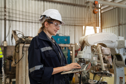 engineers and technician using laptop checking and repair pressing metal machine at factory, Machine maintenance technician operation concept. 