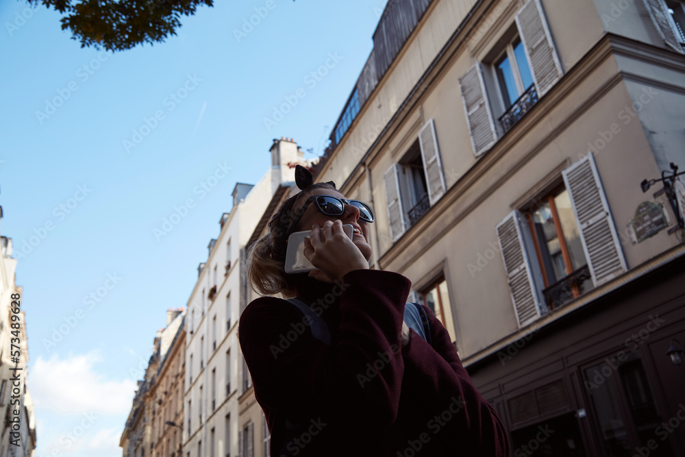 Young lady using smartphone on Paris streets.