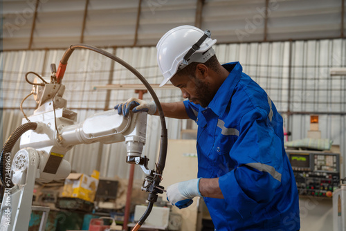 Industrial engineer wearing a white helmet working in industrial factory.